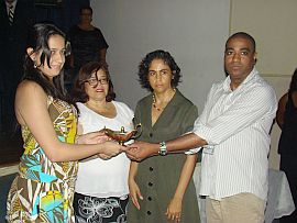 As professoras Ana Lúcia Abrahão, da UFF, e Lígia Oliveira Vianna, da UFRJ, entregaram simbolicamente a "Lâmpada da Enfermagem" aos alunos Aline Teófilo, da UFF, e Ronan dos Santos, da UFRJ